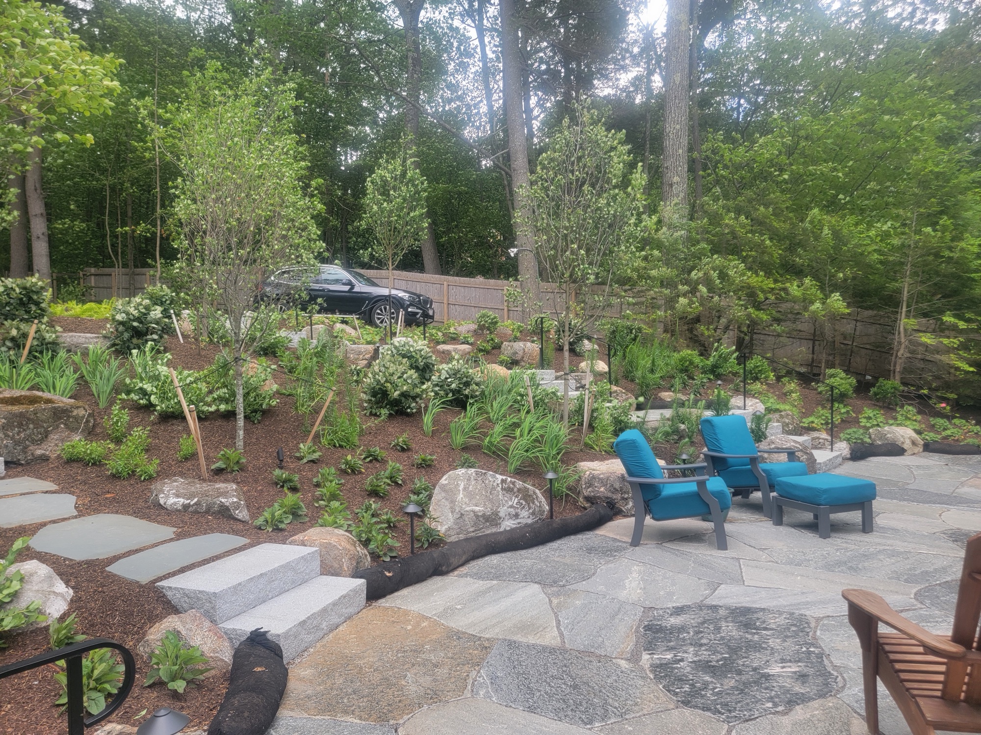 Bluestone patio with fire feature and lush plantings