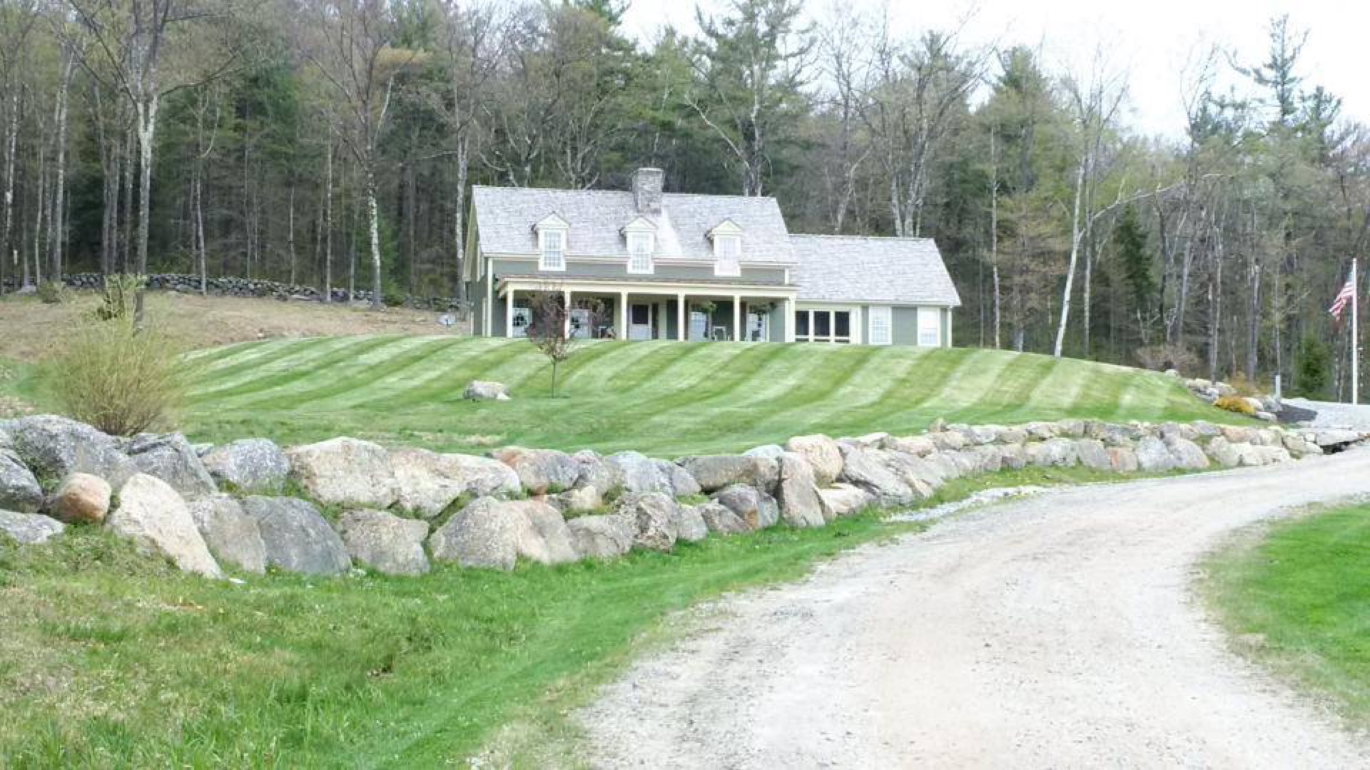 White farmhouse with a sweeping, freshly mowed lawn
